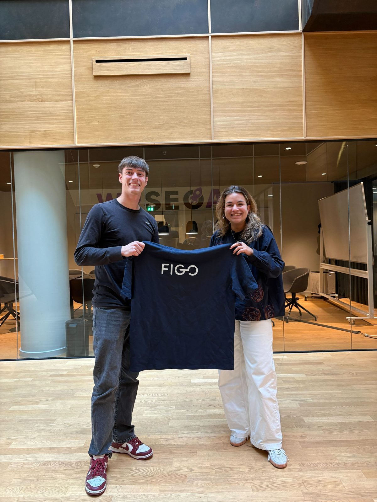 Het team van WP SEO AI met een Figo-shirt op kantoor
